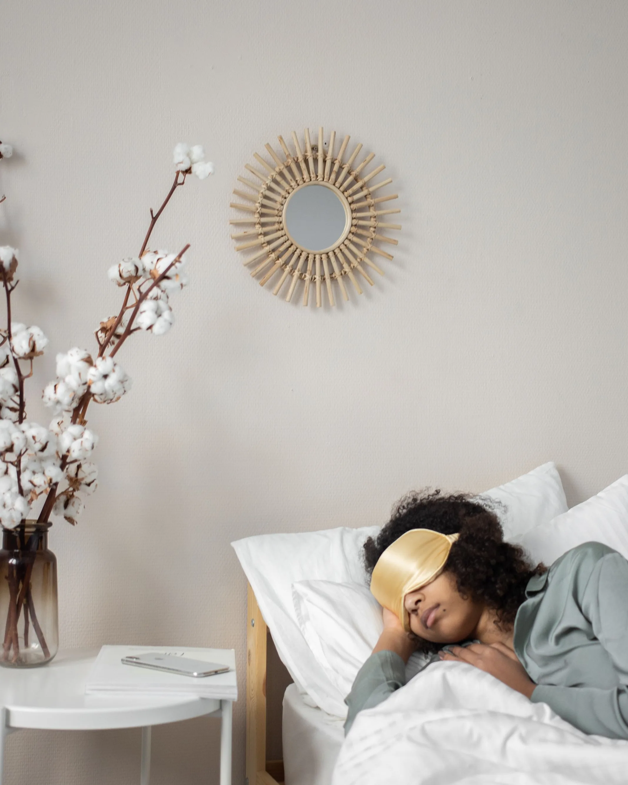 Une femme dort, un masque sur les yeux ; sur la table de chevet, seulement un verre d’eau